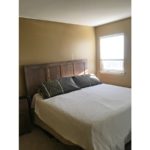 Bedroom with queen bed, nightstand, and window