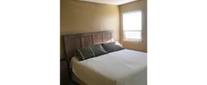 Bedroom with queen bed, nightstand, and window