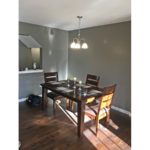 Dining room with wood-style flooring, table and chairs, and chandelier