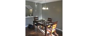 Dining room with wood-style flooring, table and chairs, and chandelier