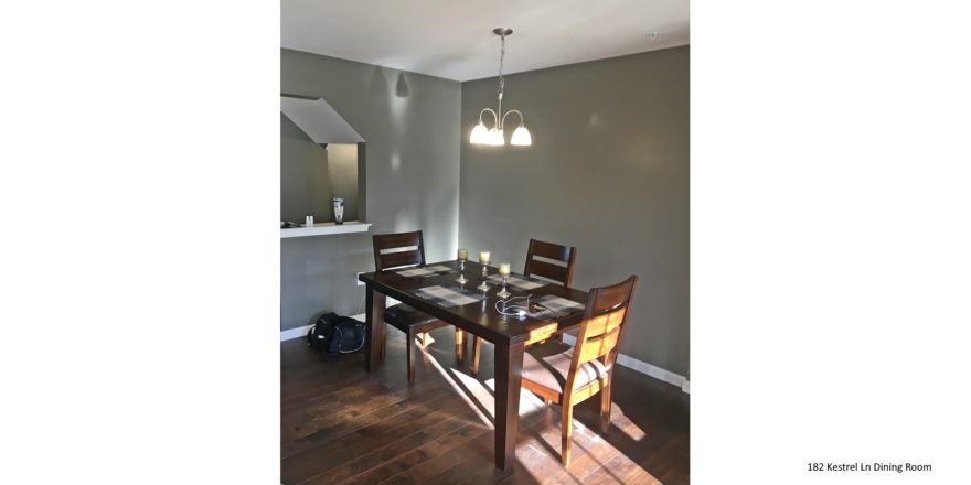 Dining room with wood-style flooring, table and chairs, and chandelier