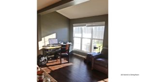 Living room with wood-style flooring, leather armchair, desk with computer and large window