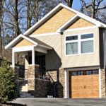 Craftsmen style house with stone siding, tan siding, and cedar shake shingle siding