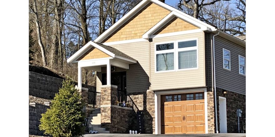 Craftsmen style house with stone siding, tan siding, and cedar shake shingle siding