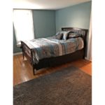 Bedroom with full bed and throw rug