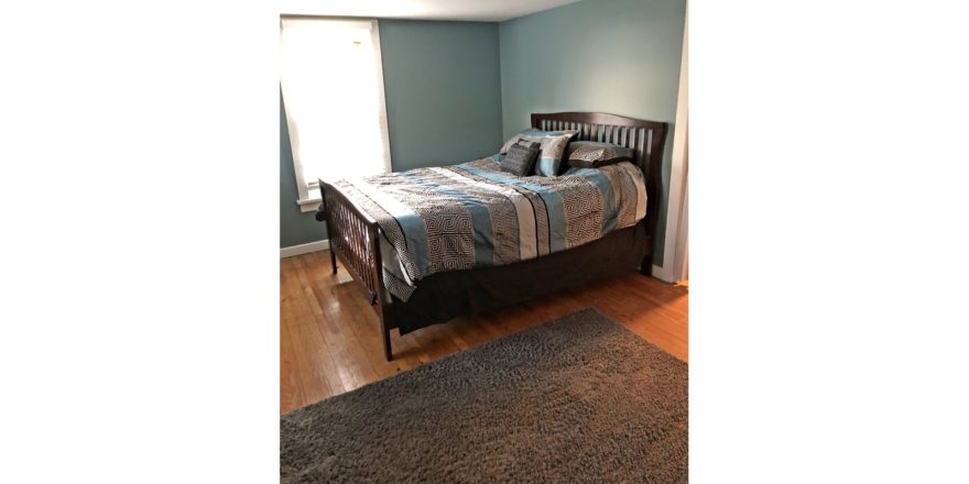 Bedroom with full bed and throw rug