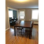 Dining room with hardwood floors and large rectangular table with five chairs