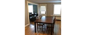 Dining room with hardwood floors and large rectangular table with five chairs