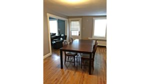 Dining room with hardwood floors and large rectangular table with five chairs