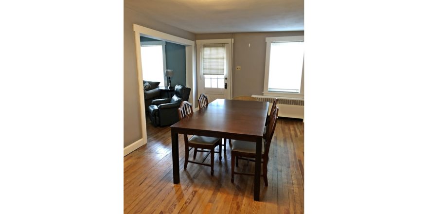 Dining room with hardwood floors and large rectangular table with five chairs