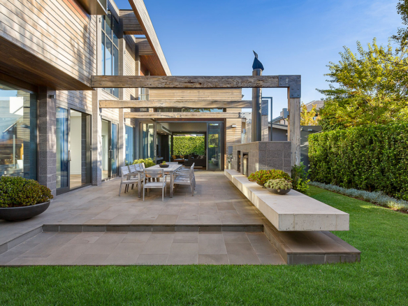 a patio with a table and chairs in front of a house