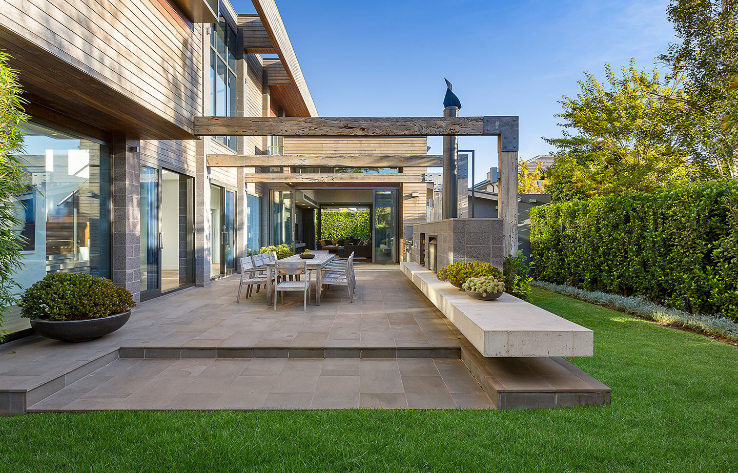 a patio with a table and chairs in front of a house