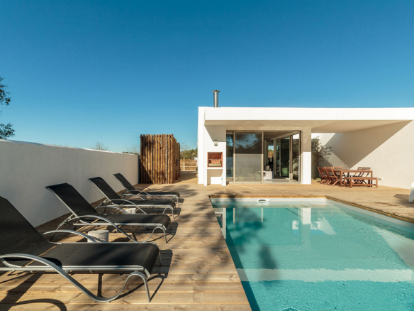 a swimming pool with lounge chairs around it