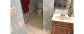 Bathroom with wallpaper, toilet, and small vanity with mirror
