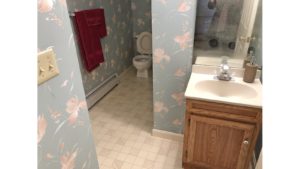 Bathroom with wallpaper, toilet, and small vanity with mirror