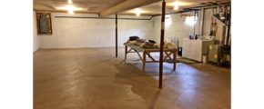 Large, unfinished basement with side-by-side front load washer and top load dryer