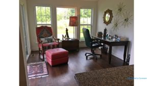 Sunroom with wood-style flooring, chair, desk with chair, mirror and large windows