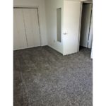 Unfurnished bedroom with gray carpet.