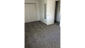 Unfurnished bedroom with gray carpet.