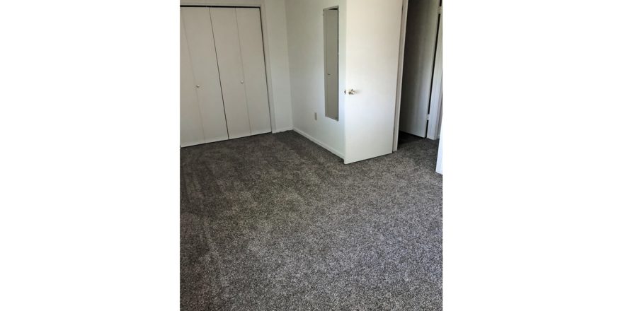 Unfurnished bedroom with gray carpet.