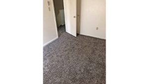 Unfurnished bedroom with gray carpet.