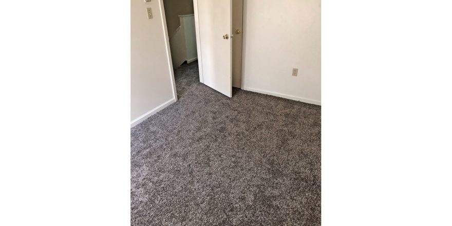 Unfurnished bedroom with gray carpet.