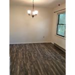 Unfurnished dining room with wood-style flooring and chandelier.