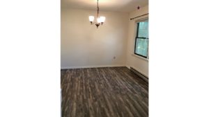 Unfurnished dining room with wood-style flooring and chandelier.