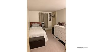 Bedroom with twin bed, dresser, window and storage ottoman