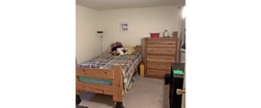 Bedroom with twin bed, dresser, and bookshelf