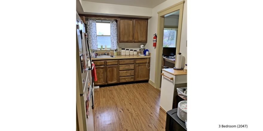 Kitchen with white appliances, wood-style flooring and wood cabinets