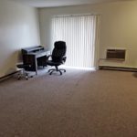 Carpeted living room with desk and desk chair