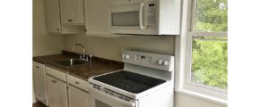 Kitchen with white cabinets, sink and white appliances