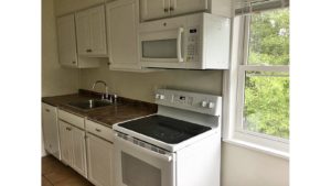 Kitchen with white cabinets, sink and white appliances