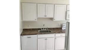Kitchen with white cabinets, sink and white appliances