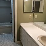 Bathroom with large vanity, tub/shower combo, and toilet