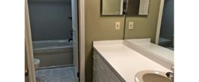 Bathroom with large vanity, tub/shower combo, and toilet