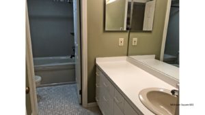 Bathroom with large vanity, tub/shower combo, and toilet