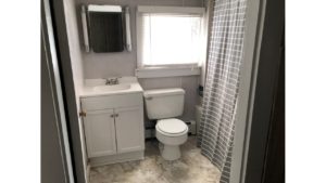 Bathroom with toilet, tub/shower combo with curtain, vanity, and medicine cabinet with a mirror