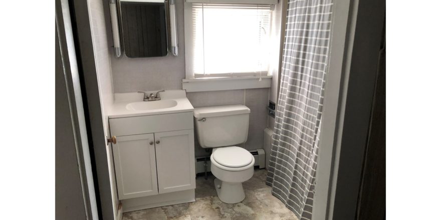 Bathroom with toilet, tub/shower combo with curtain, vanity, and medicine cabinet with a mirror
