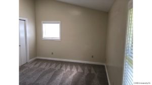 Carpeted, unfurnished bedroom with two windows and closet