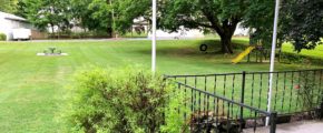 Large yard with bench, tire swing, and small play fort