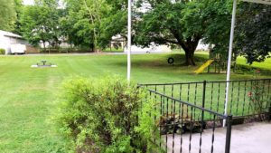 Large yard with bench, tire swing, and small play fort