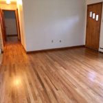 Unfurnished living room with hardwood floor and entry door