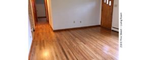 Unfurnished living room with hardwood floor and entry door