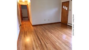 Unfurnished living room with hardwood floor and entry door