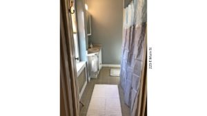 Bathroom with tub/shower combo with curtain, toilet, and vanity, and medicine cabinet with mirror