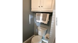 Bathroom with toilet and cabinet above the toilet
