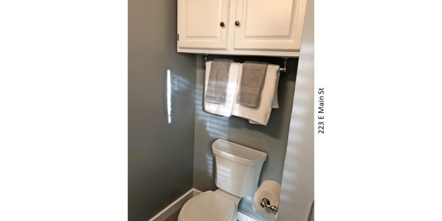 Bathroom with toilet and cabinet above the toilet