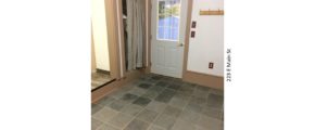 Mudroom with tile floors, closet with a curtain for a door, and back door